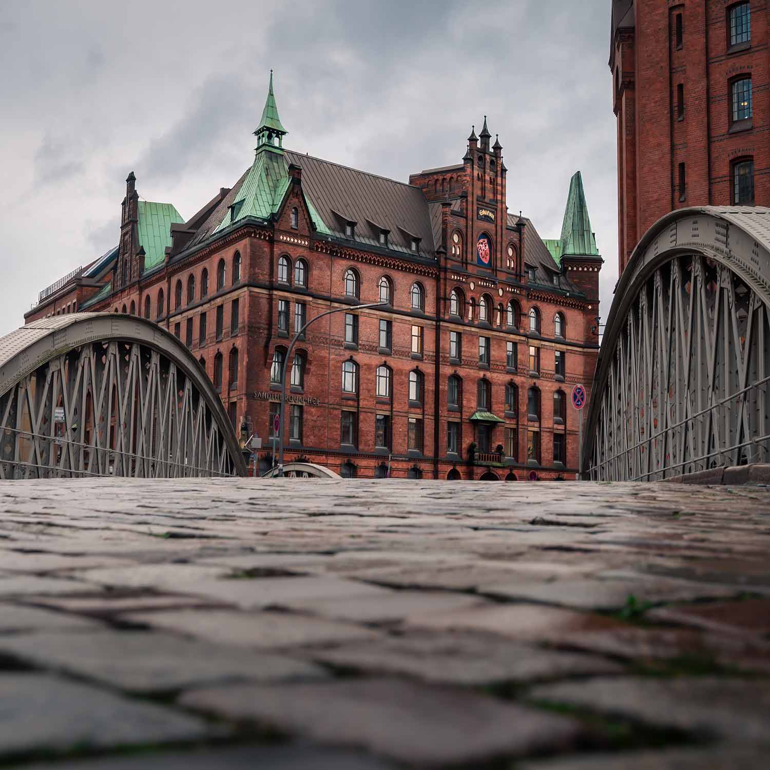 Small group walking through Speicherstadt warehouse district with Elbphilharmonie in background